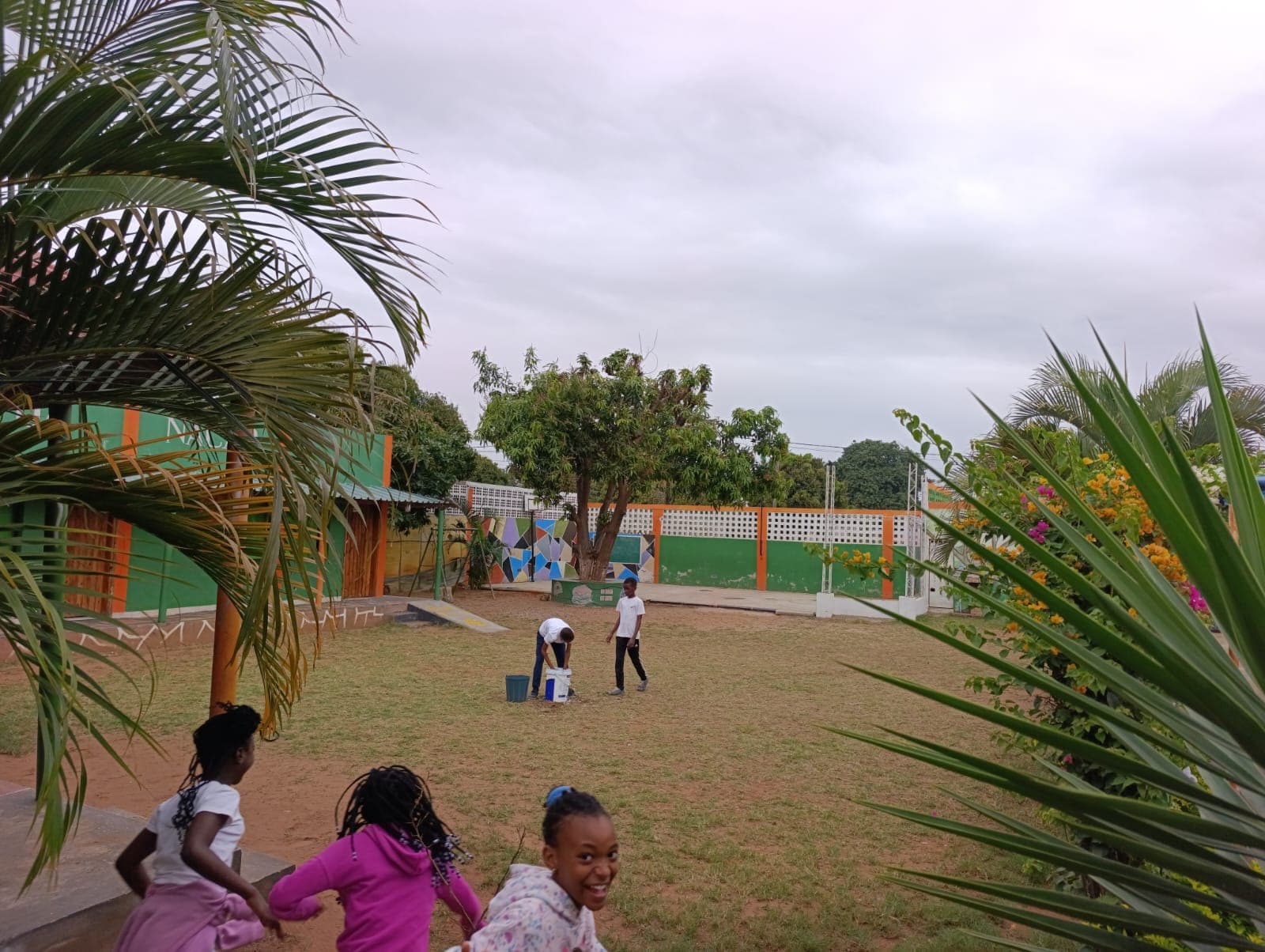 Crianças a brincar, com o edifício da escola ao fundo.